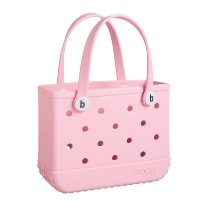 Pink tote bag with two handles and the capital letter "B" in the center. "Bitty Bogg Bag" is written on the bag.