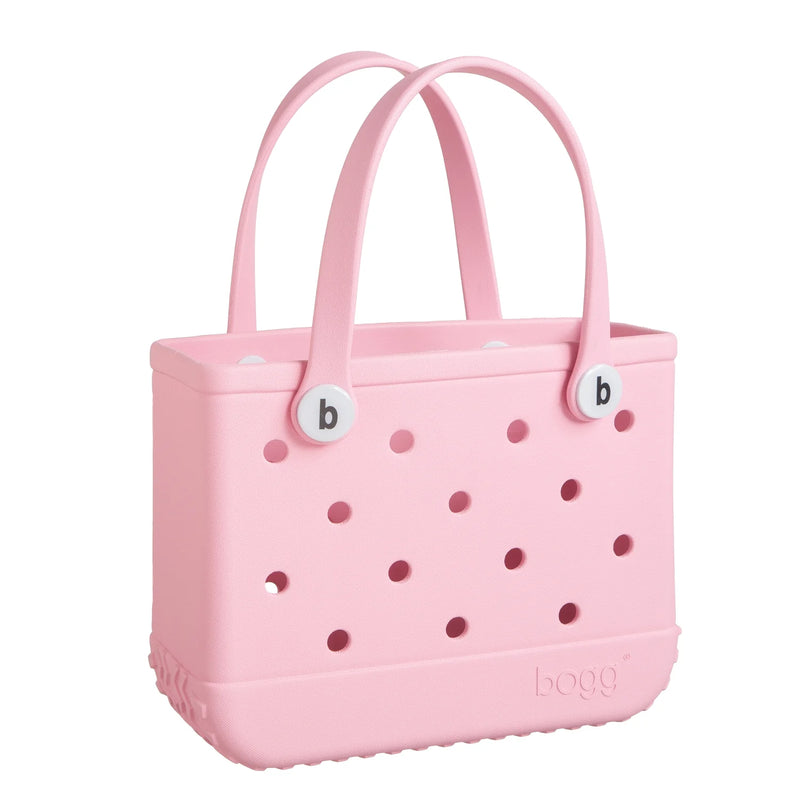 Pink tote bag with two handles and the capital letter "B" in the center. "Bitty Bogg Bag" is written on the bag.